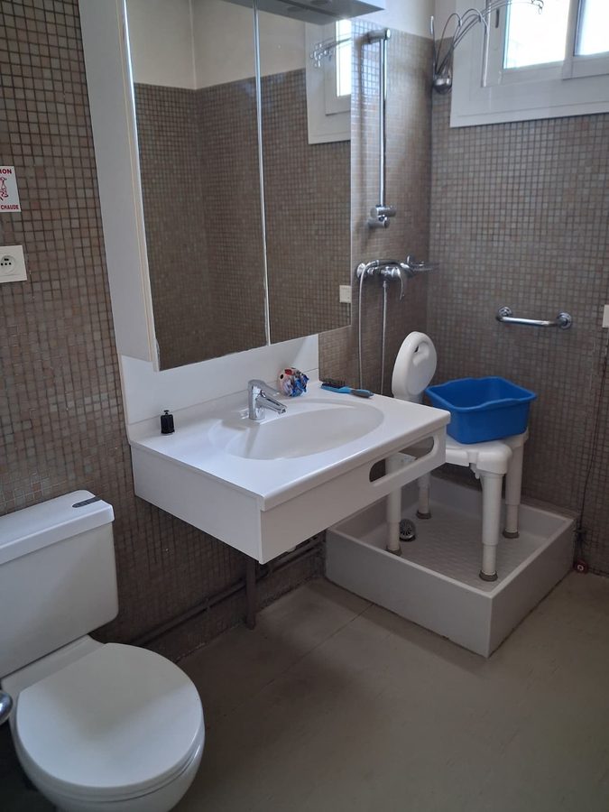 Salle de bain accessible PMR à Brignoles — vasque suspendue, douche plain-pied, mosaïque